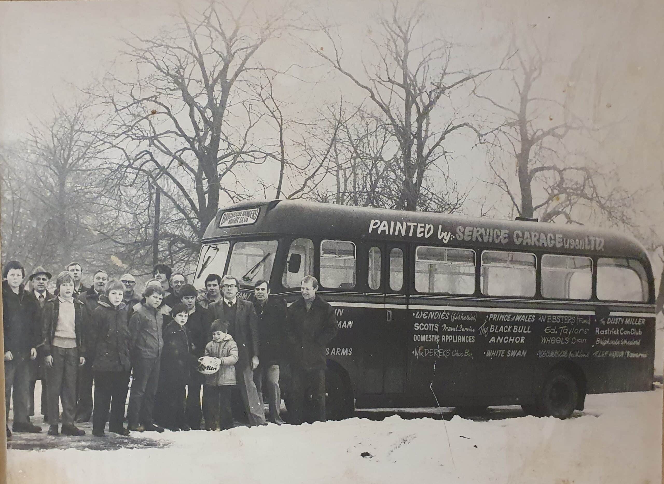 black and white photo of people stood at the front of a bus in the snow