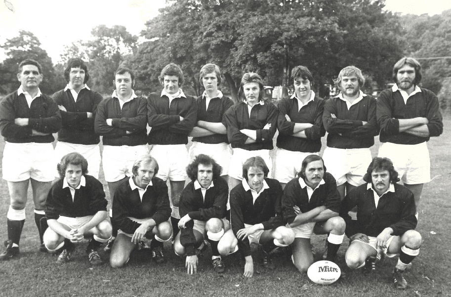 Black and white photo of the team standing in a row and the row in front sitting in their kits