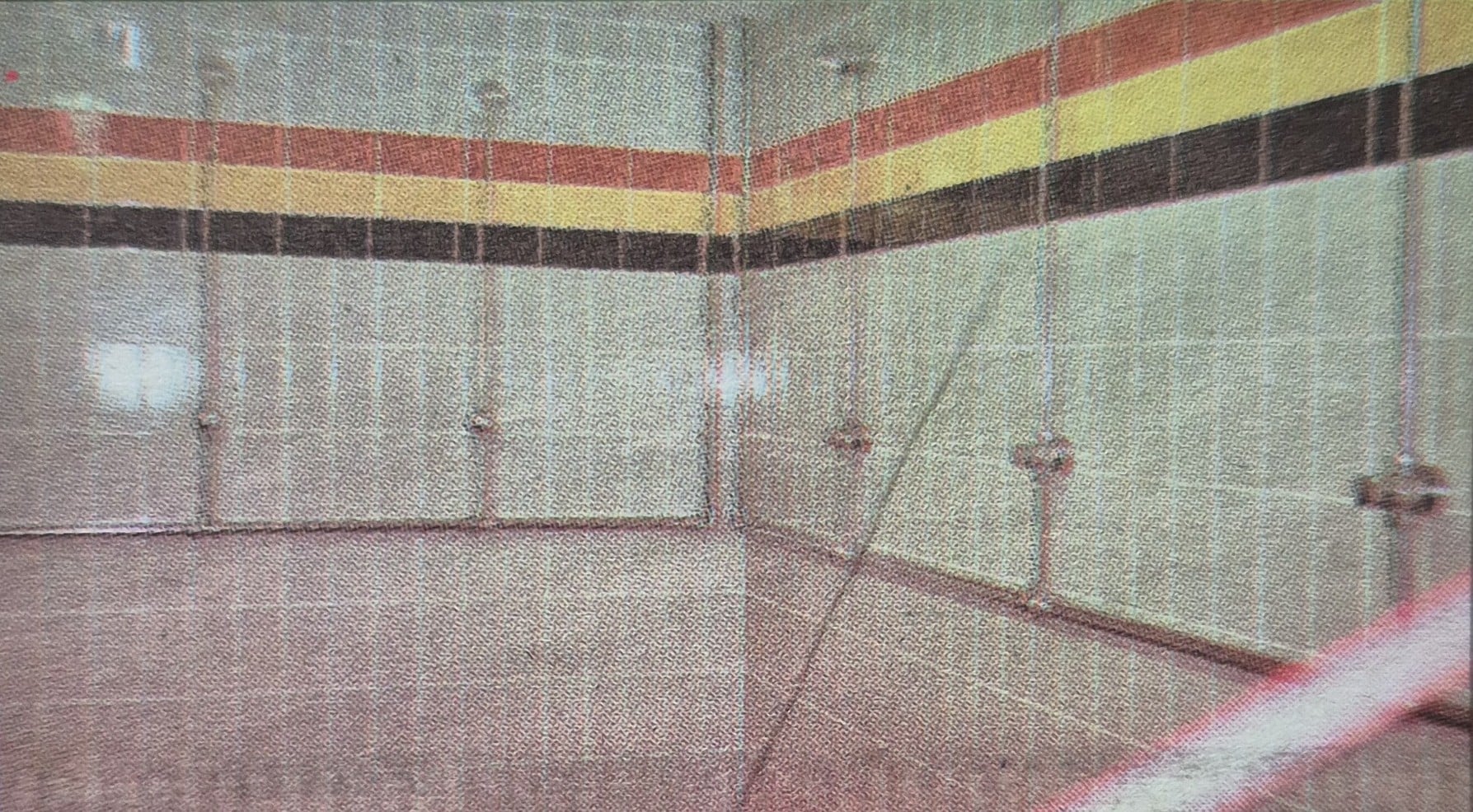 old photo showing the inside of Brighouse Rangers showers- with red yellow and black striped tiles 