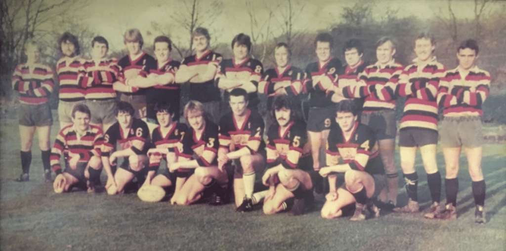 Old team photo with team in two rows, one standing, one sitting, wearing kits