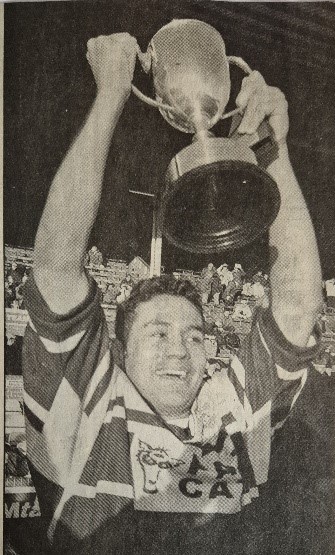 black and white photo of Elland Captain Junaid Malik lifting the trophy in 2001-2 Yorkshire Cup