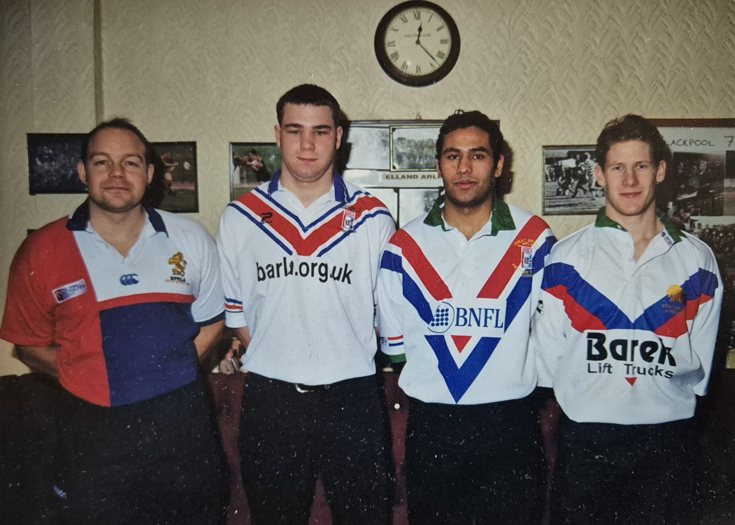 colour photo of four players standing in a row in rugby tops for the photo