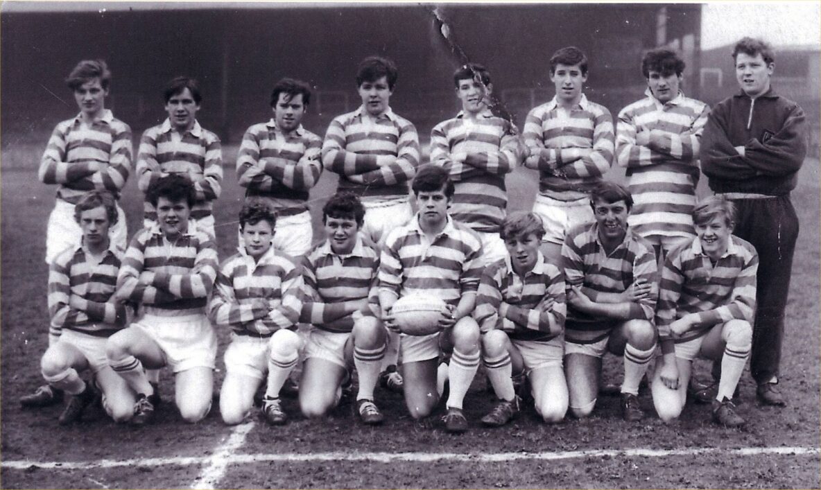 black and white photo of team wearing stripey kits, in two rows on a pitch