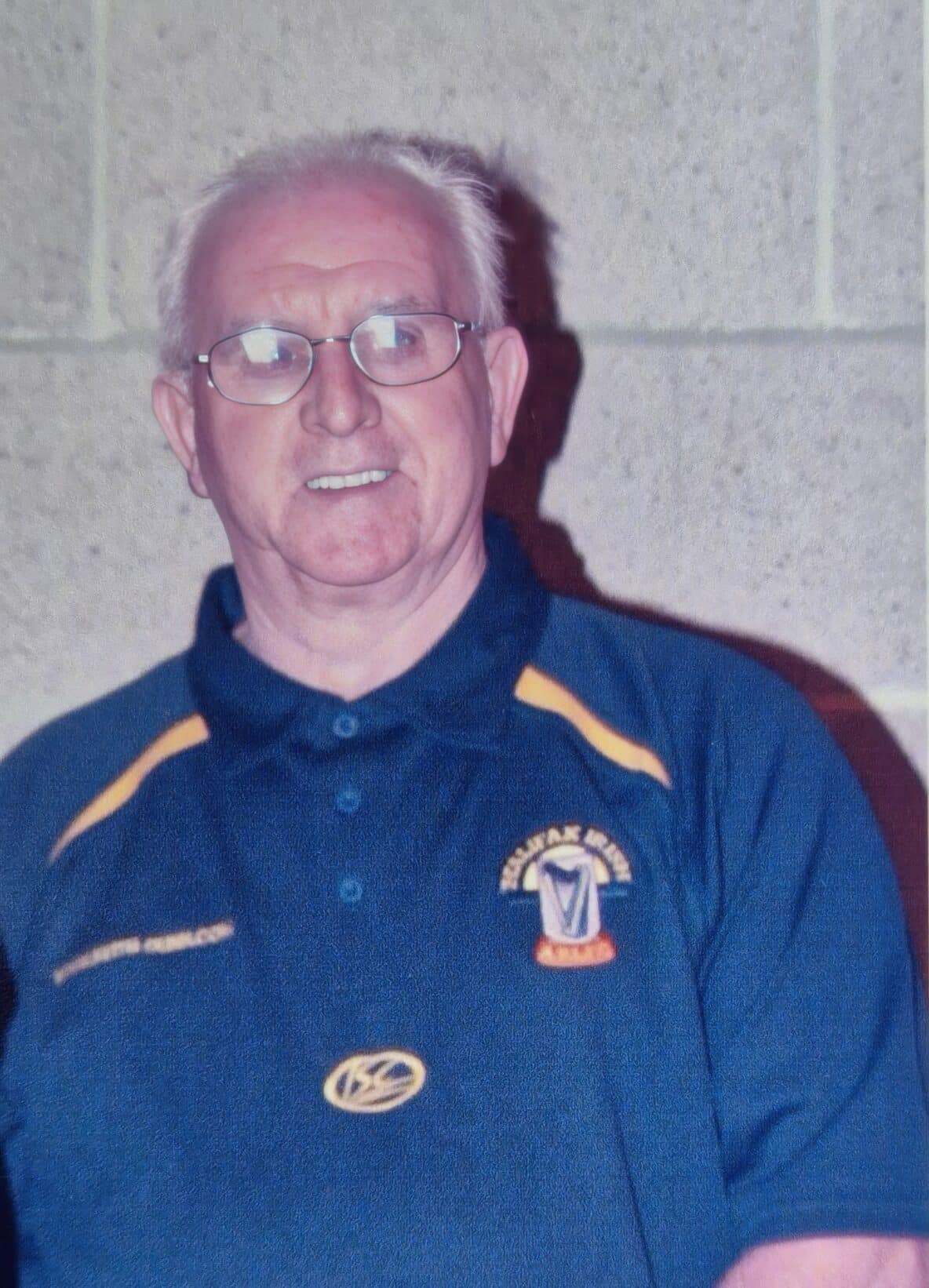 photo of a person with white hair and glasses smiling