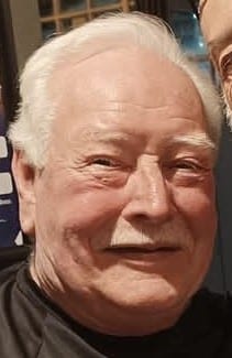 colour photo of Dougie Booth's head, who is smiling and has white hair