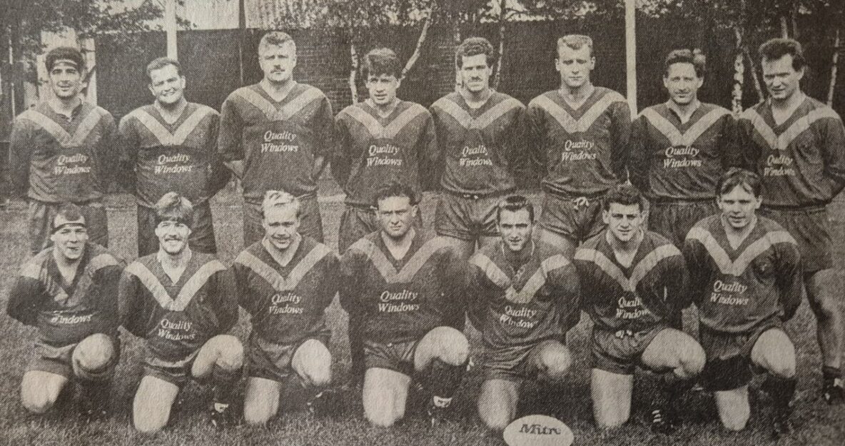 black and white team photo of players in two rows, wearing kits which said "quality windows" over the chest, all players have their arms behind their backs