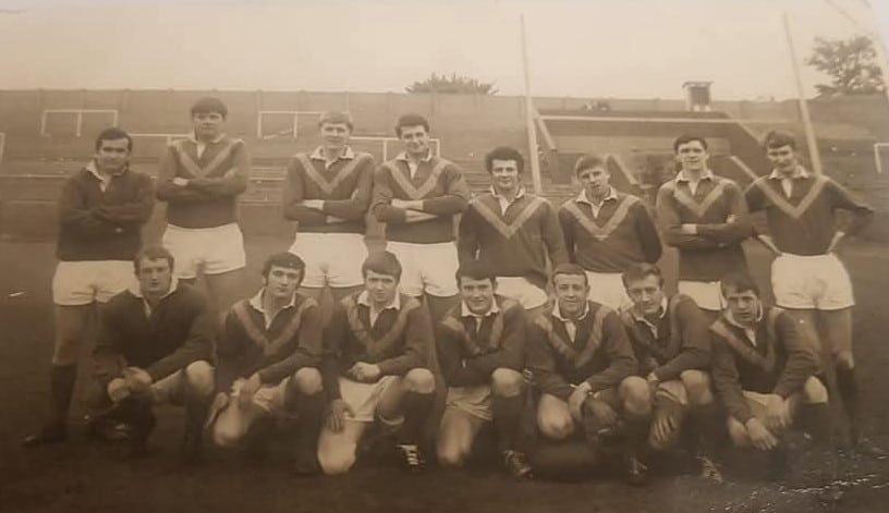 old sepia team photo of team in two rows, wearing their kits, standing on the pitch
