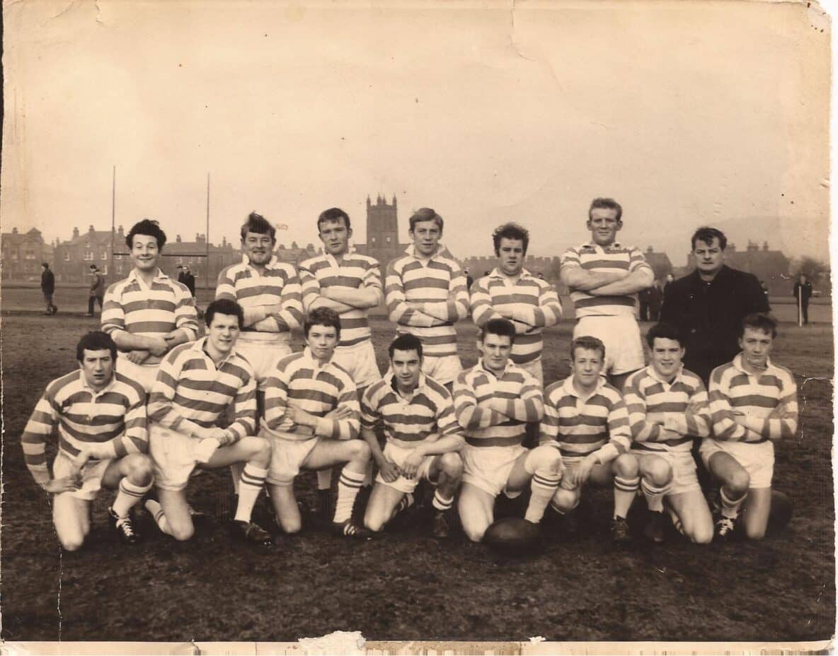 old sepia photo of a team on the field, in two rows, wearing their stripey kits