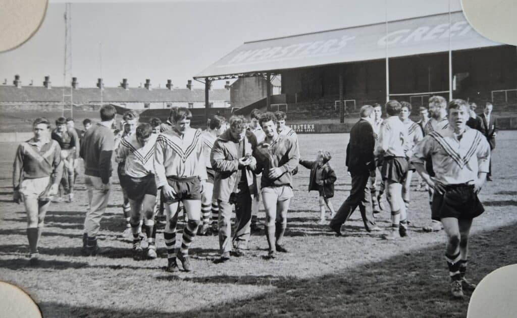 old black and white photo of players walking off the pitch