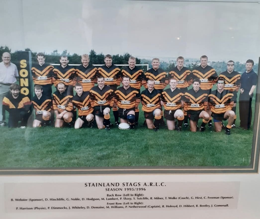 colour photo of a team photo, where players are wearing their kits, in two rows on the pitch