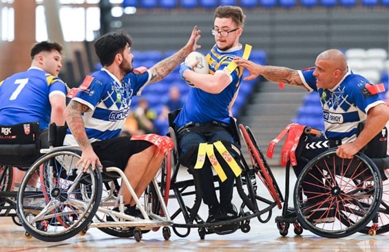colour action shot photo of wheelchair team mid-match on the court