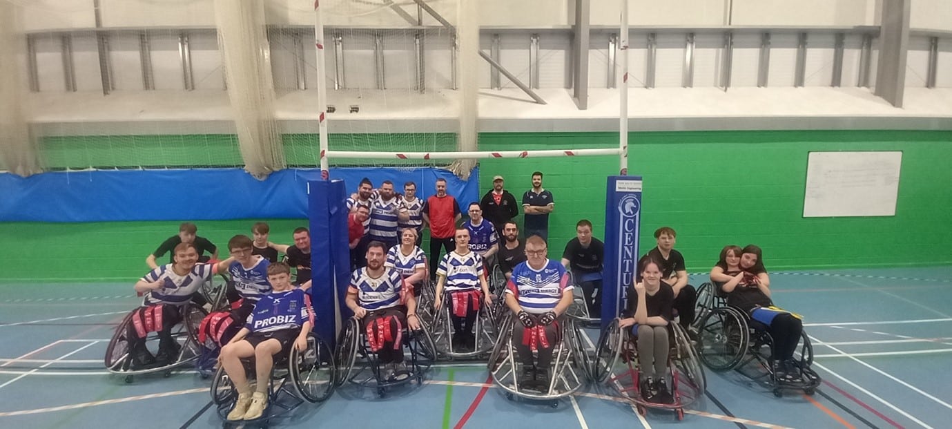 colour photo of team who are in a group on the court, against a bright green wall