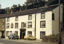 colour photo of Grove Inn at Brierley which is a set of terraced buildings that have a light-coloured exterior, with a few cars parked outside