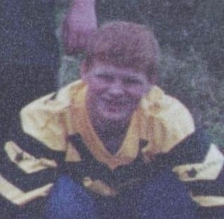 newspaper colour photo of a young player, who has short ginger hair and is wearing a yellow and blue striped long sleeved top 