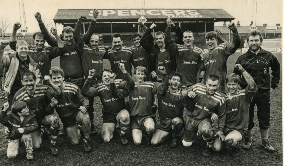 black and white photo of the Siddal 'A-Team' celebrating and cheering in a group