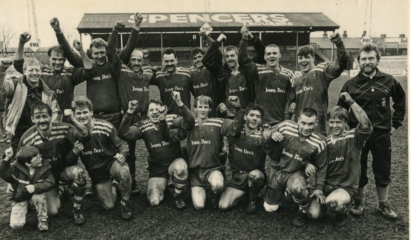black and white photo of the Siddal 'A-Team' celebrating and cheering in a group