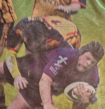 colour newspaper photo of a midgame tackle 