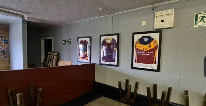 colour photo of the inside of a room, with rugby shirts framed on the wall