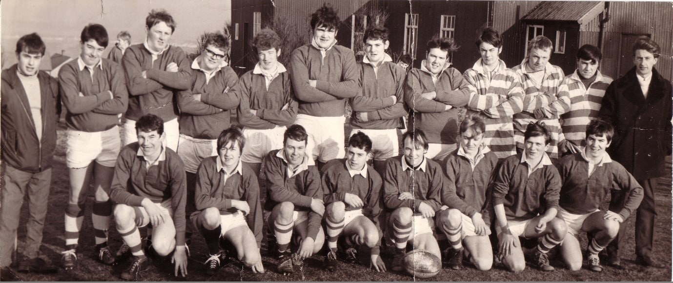 Halifax Supporters Junior ARLFC team photo, two rows of team members stand in their kits for the black and white photo, most in the back row are crossing their arms, the front row are kneeling on one knee with their elbow on the other knee