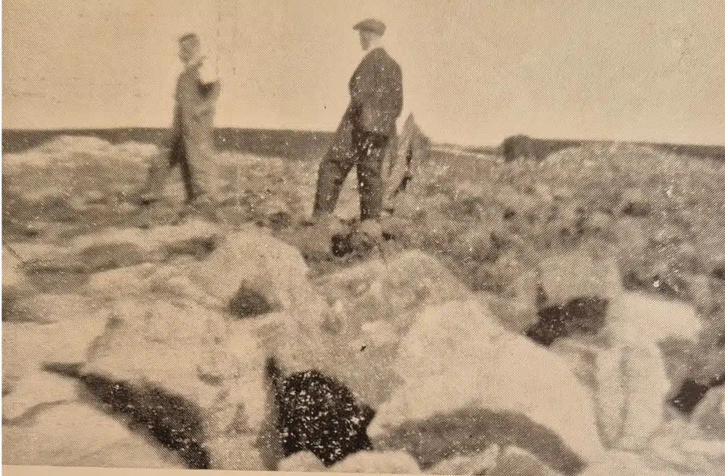 old sepia photo of two people walking on rocky terrain, which is the view from Rochdale Road towards Norland in 1952
