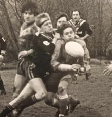 black and white action shot photo of player Steve Dyson during a tackle in a game 