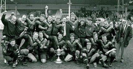 black and white photo of Greetland players celebrating on the pitch after a victory over Siddal