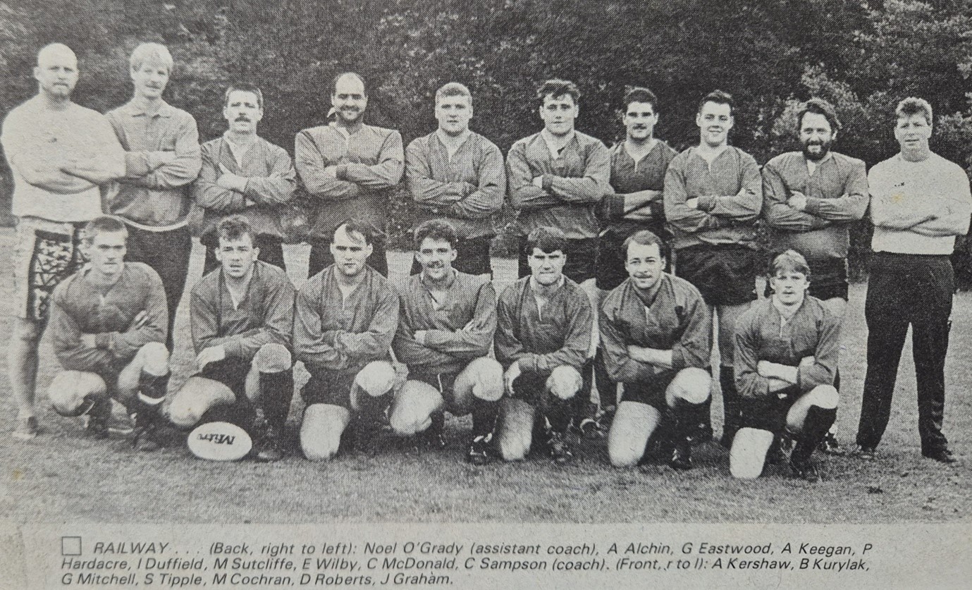 black and white team photo of team wearing kits, in two rows with names below in print
